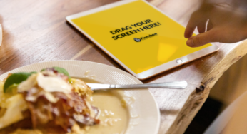 Woman uses pink Apple iPad during delicious business lunch