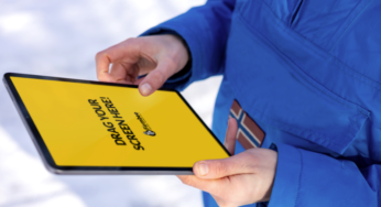 Man in blue jacket uses Apple iPad
