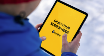 Man in blue jacket uses Apple iPad in the park