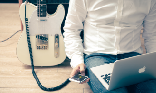 Man with guitar & Apple devices