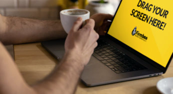 Man drinks coffee while working on Apple MacBook
