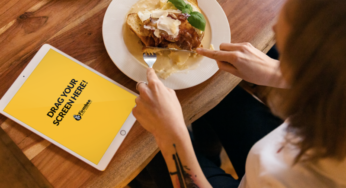 Woman with tattoo and iPad eats lunch